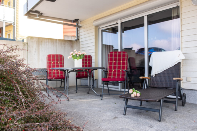 Terrasse mit Stühlen, Tisch und Liegen